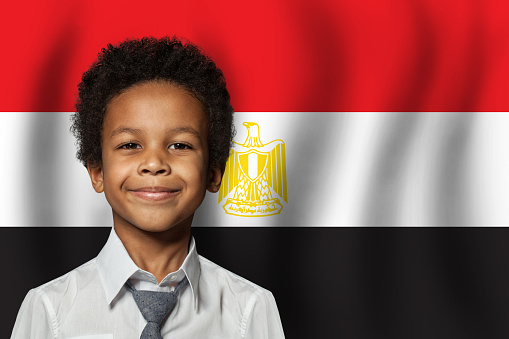Egyptian kid boy on flag of Egypt background. Education and childhood concept