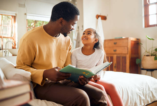 istock Black family, dad reading book to child for learning, support and language development, bonding in bedroom. Happy people, father and girl love with creative storytelling, education or home teaching 1474723710