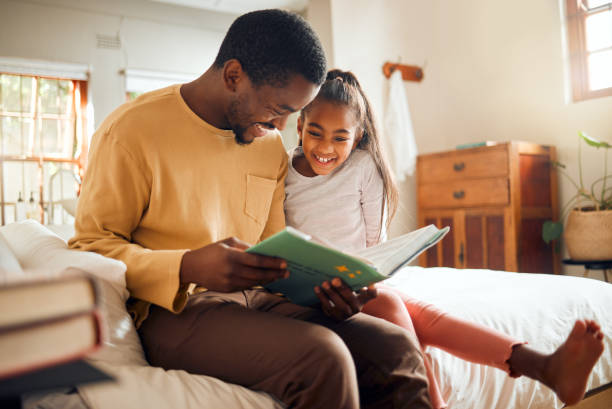 istock Black family, storytelling father and child for language support, help and learning bonding and love at home. People, person or dad and girl reading book for creative knowledge, education in bedroom 1474723713