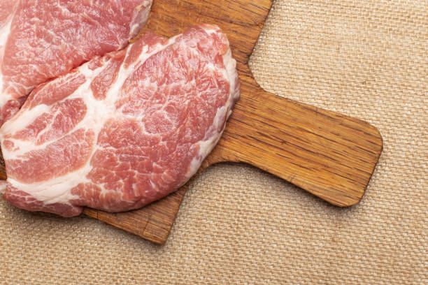 Raw fresh meat. Raw pork steak on a wooden board. Raw fresh meat. Raw pork steak on a wooden board. beef pad stock pictures, royalty-free photos & images