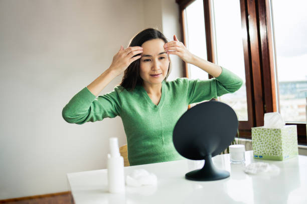 istock Woman applying moisturizer on face 1474726124