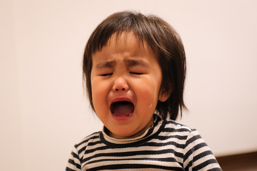 Asian Little girl crying indoors