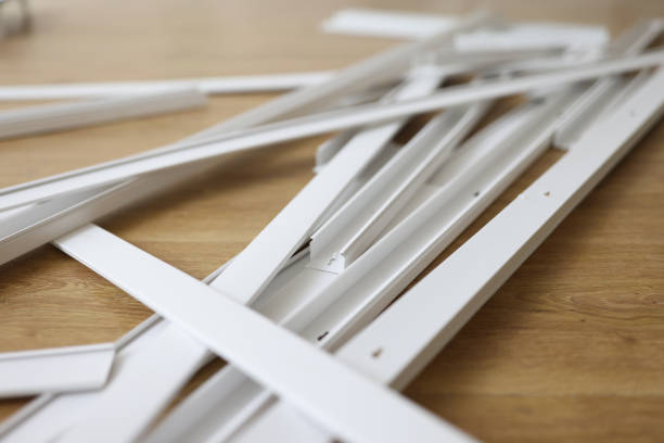 Lots of white plastic cable trays on the wooden floor. Lots of white plastic cable trays on the wooden floor. Electrical cable repair and house renovation concept. pvc conduit stock pictures, royalty-free photos & images