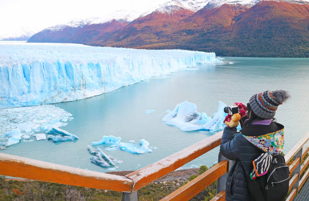 visitante femenina tomando fotos del glaciar perito moreno, un increíble sitio declarado patrimonio de la humanidad por la unesco en la patagonia, argentina, américa del sur - patagonia el calafate horizontal argentina fotografías e imágenes de stock