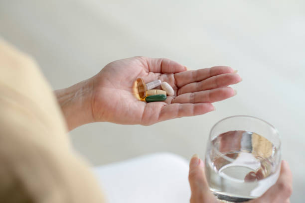 istock Woman holding pills in hand 1474743690