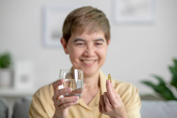 istock Smiling mature woman taking pill and vitamin, selective focus on pill. 1474743723