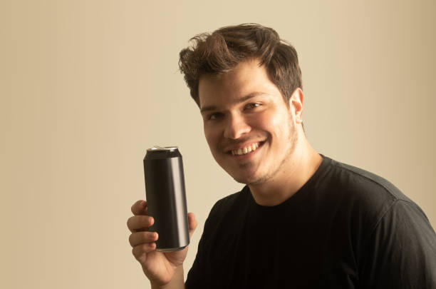 istock Smiling young man holding tin beverage bottle. 1474746275