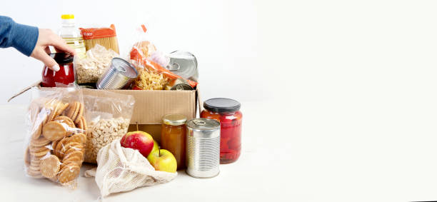 Food donations Food donation box of different products on light background, top view. Food donations or delivery concept. Panorama, banner, copy space donation box stock pictures, royalty-free photos & images