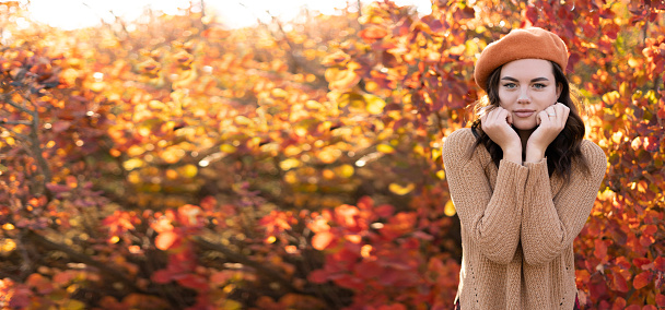 Sad girl over autumn leaves background. Copy space. Banner