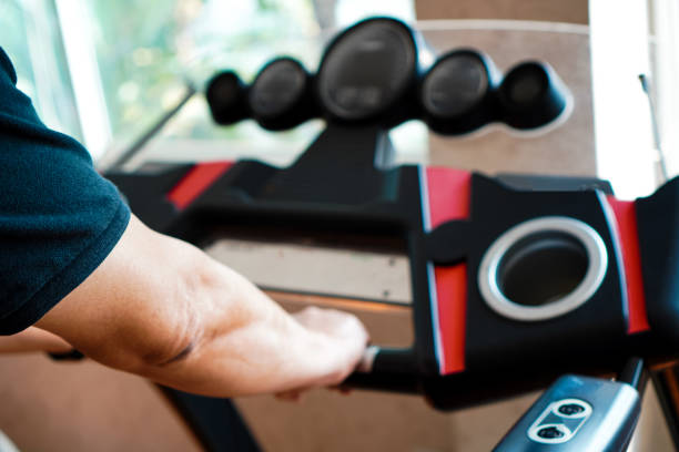 istock An image showing a hand holding a treadmill while exercising in a gym. 1474751614