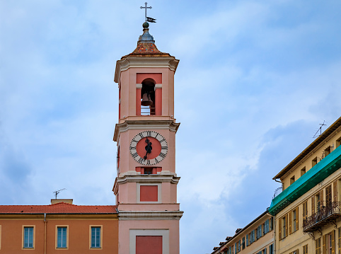 The Caserne Rusca clock tower with restaurants and shops in front of it in the streets of the Old Town, Vieille Ville of Nice France