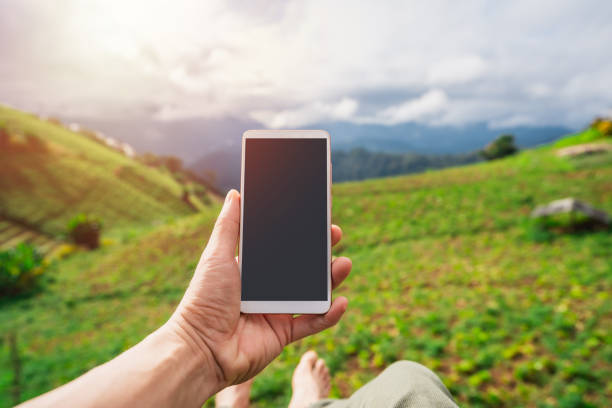 istock Young man traveler relaxing and using a mobile phone while traveling with beautiful landscape 1474753058