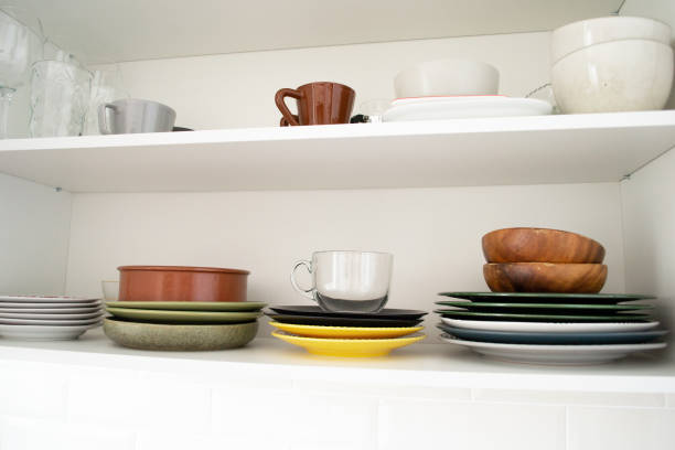 istock Multicolored dishes on a shelf in a white kitchen cabinet. 1474757066