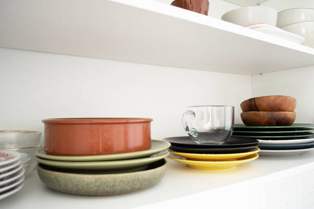 istock Multicolored dishes on a shelf in a white kitchen cabinet. 1474757087