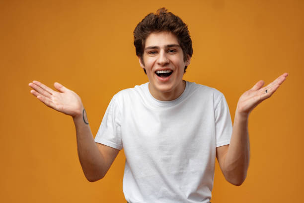 istock Young man standing over yellow background clueless and confused with open arms 1474757273