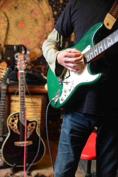 istock Young man plays electric guitar 1474757482