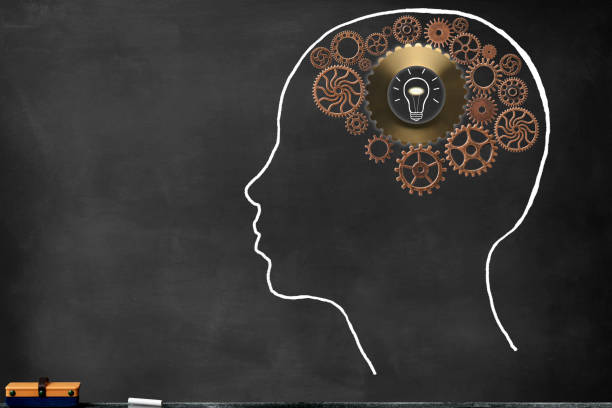 istock Metal gears inside the chalk drawn human head shape on blackboard, and illuminated light bulb 1474758677