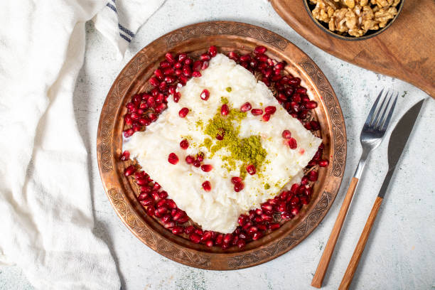 Gullac dessert. Ramadan dessert. Gullac decorated with pomegranate and pistachio in copper plate on gray background. Symbolic food stock photo