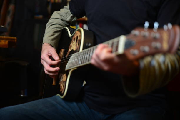 istock Young man plays electric guitar 1474762573