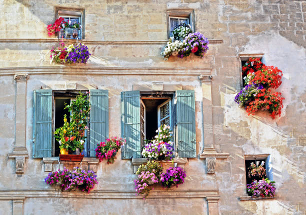 facciata tipica della vecchia casa retrò provenzale con finestre e persiane in legno decorate con fiori freschi colorati in provenza, costa azzurra, francia - cote d’azur foto e immagini stock