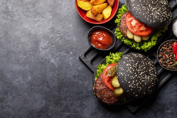 istock Homemade beef burgers with black buns 1474766701