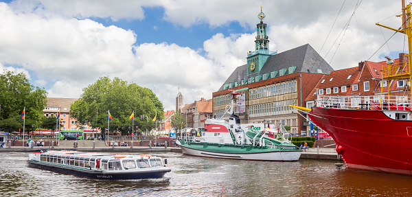 Panorama of a cruiseboat in front of the historic town hall of Emden, Germany