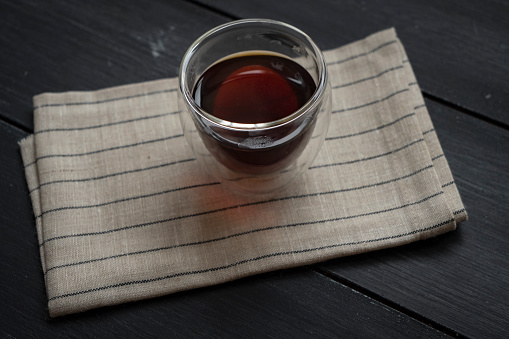 Close-up a transparent mug of rooibos tea and rooibos on the old wooden table outdoors. Healthy eating concept