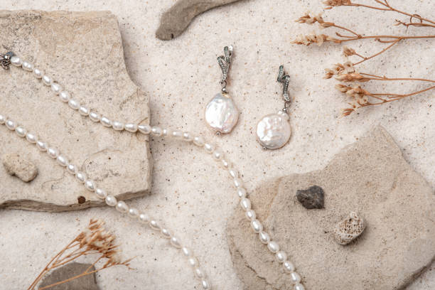 красивые жемчужные украшения на белом песке. - jewelry antique pearl gem стоковые фото и изображения