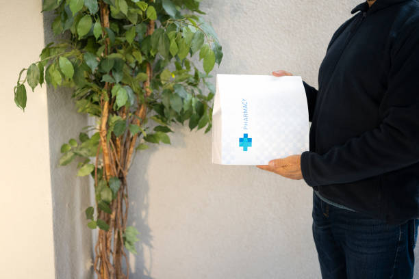 istock Delivery person holding medicine package 1474770947