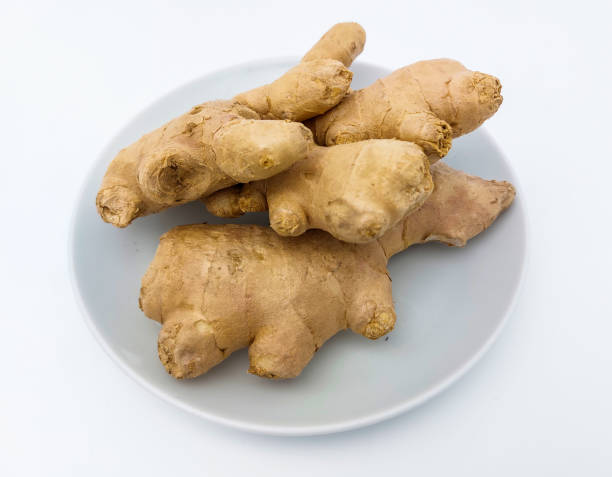 istock Fresh ginger rhizome on a white plate, isolated on white background. Close up view. 1474771138