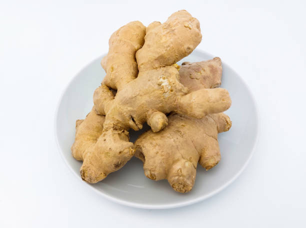 istock Fresh ginger rhizome on a white plate, isolated on white background. Close up view. 1474771191