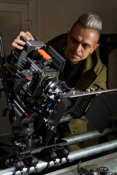 istock a handsome caucasian videographer tilted a professional movie camera and monitors the shooting on the monitor. the camera stands on operator rails and a trolley 1474771233