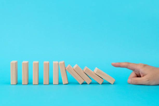 istock Woman hand pushing domino pieces 1474771283