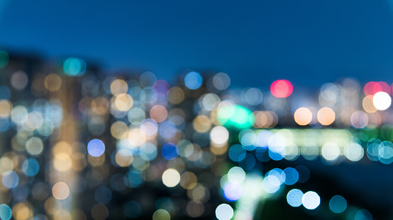 Abstract blurred background cityscape of Krung Thep Maha Nakhon (Bangkok) on night scene with multicolour bokeh from neon light on building