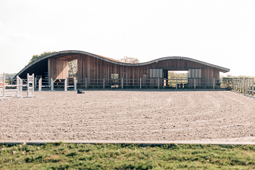 design stables in a horse education center - modern horse farm with wooden and steel structures - daylight