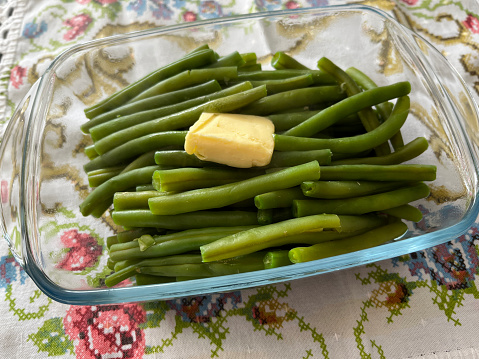 Steaming green beans in dish with nob of butter on top