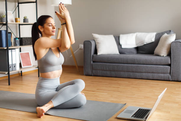 istock Young woman stretches at home after exercising 1474776033