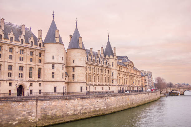 The Conciergerie and the river Seine in Paris, France The Conciergerie and the river Seine in Paris, France musee du louvre stock pictures, royalty-free photos & images