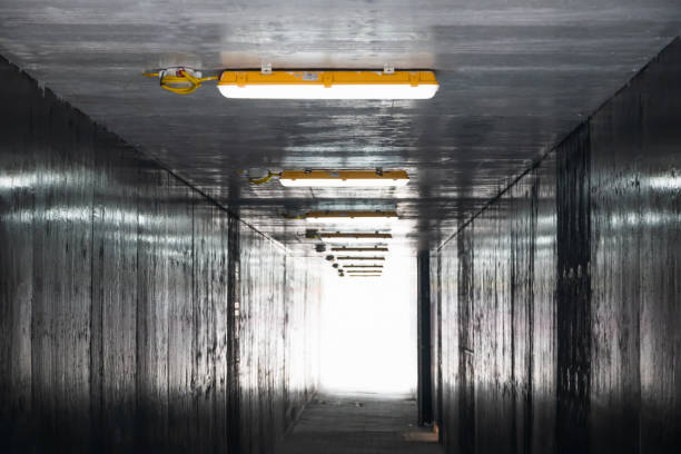 istock Dim pedestrian tunnel toward to light at the end 1474777103