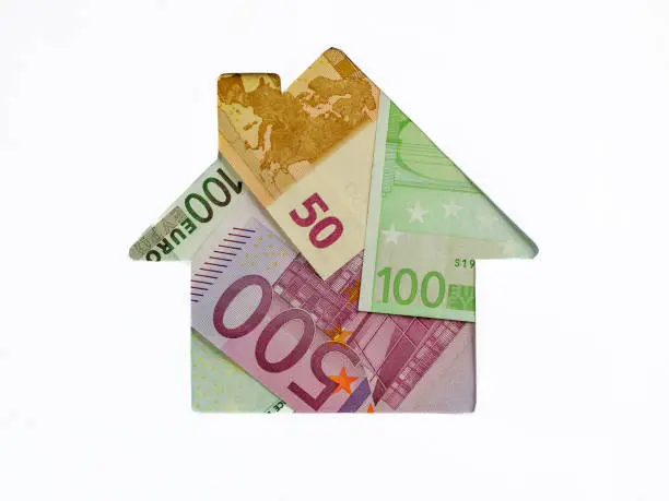 Euro banknote in shape of house on white background. Concept of Investment property, Mortgage concept. Investment risk and uncertainty in real estate housing market, utility bills. Top view flat lay.
