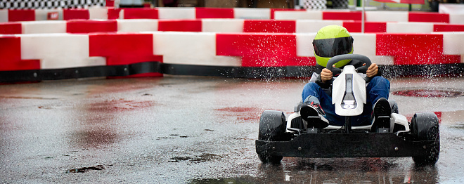 Competitive Latin American man racing in go-carts and crossing the finishing line