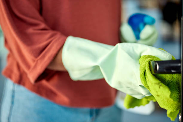Hand, woman and sanitizing with spring cleaning a door handle surface with a cloth. Busy with routine housework and chores with zoom, hygiene and germ free living space, glove and clean bacteria mano, mujer y desinfección con primavera limpiando la superficie de la manija de una puerta con un paño. ocupado con las tareas domésticas y las tareas rutinarias con zoom, higiene y espacio vital libre de gérmenes, guantes y bacterias limpias