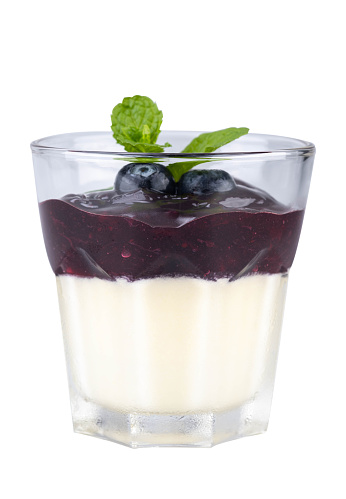 Blueberry Panna Cotta in a clear glass Top with fresh blueberries and mint leaf , isolated on white background with clipping path