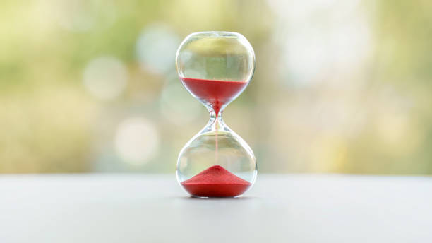 Red hourglass with blurred nature background