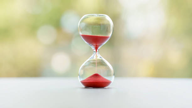 Red hourglass with blurred nature background stock photo