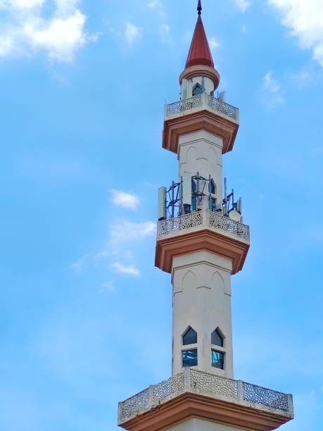 istock Distant focus of a mosque minaret isolated on blue and cloudy background 1474787567