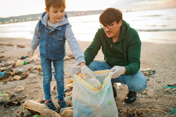 istock Family volunteers cleans a beach by gathering discarded plastic waste. Environmental pollution and ecological problems concept. 1474788574