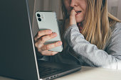 Cropped portrait of female blogger biting fingers nervous using mobile phone. Panic, shock, bulling concept. High quality toned photo about technology and security.