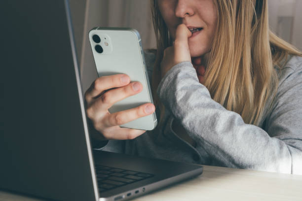 cropped portrait of female blogger biting fingers nervous using mobile phone. panic, shock, bulling concept. high quality toned photo about technology and security. - biting lip imagens e fotografias de stock