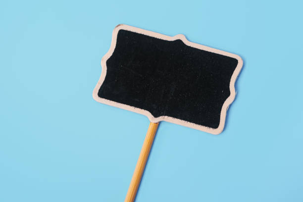 istock Blank simple wooden easel mini blackboard with faded chalky surface on blue background. View from above. Copy space for your text. Image for business, education, equipment concept 1474789600